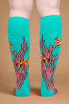 Teal socks with clownfish and coral design on a white background
