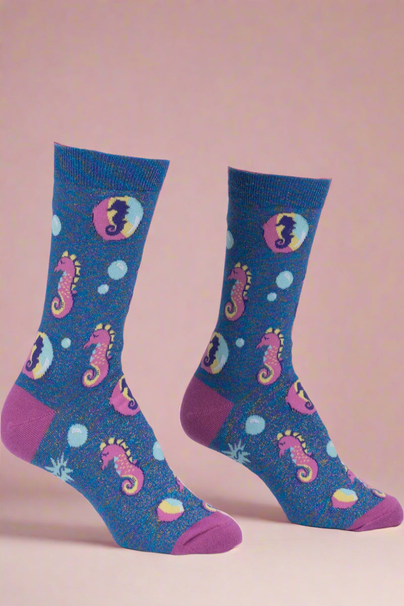 Blue socks with pink seahorse designs on a white background