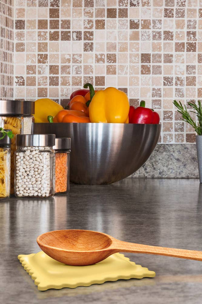 Wooden spoon on a yellow napkin with a kitchen setting in the background