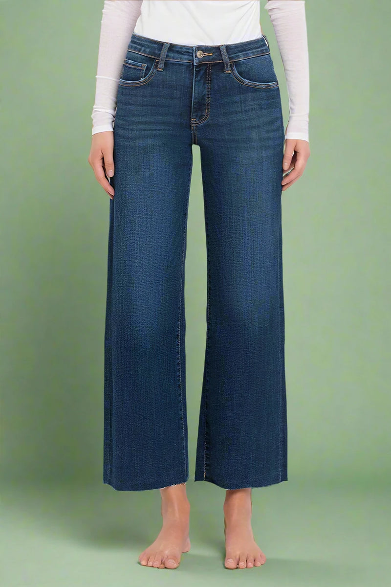 Person wearing blue wide-leg jeans on a plain background.
