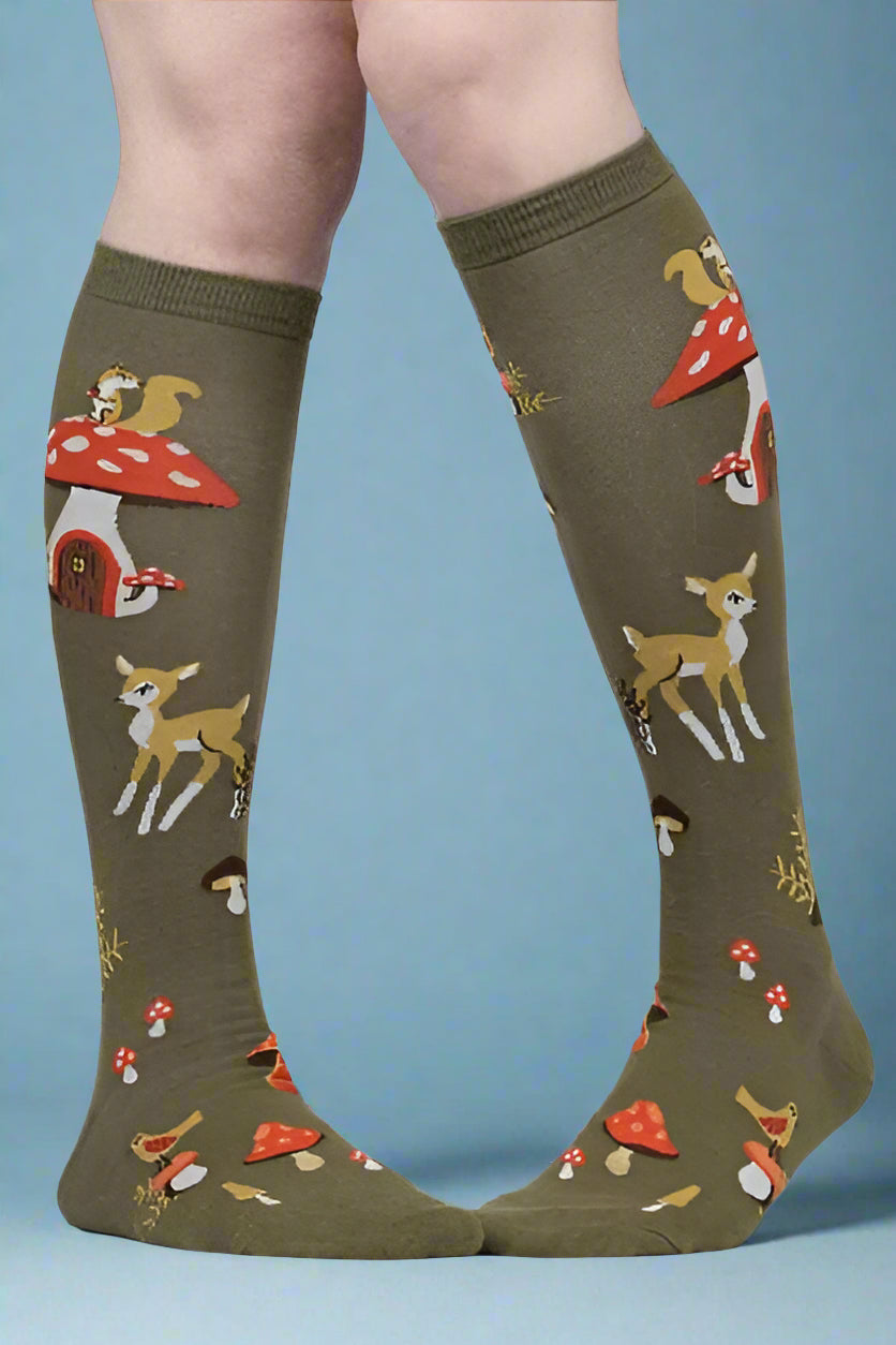 Knee-high socks with forest animal pattern worn by a person on a white background