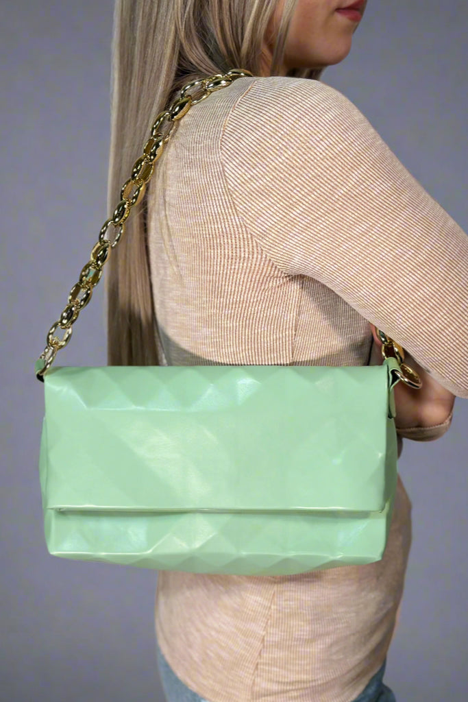 A mint bag with subtle diamond pattern and gold shoulder strap. Optional crossbody strap included..