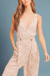 Woman wearing a floral jumpsuit on a beige background