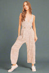 Woman wearing a sparkly jumpsuit on a beige background