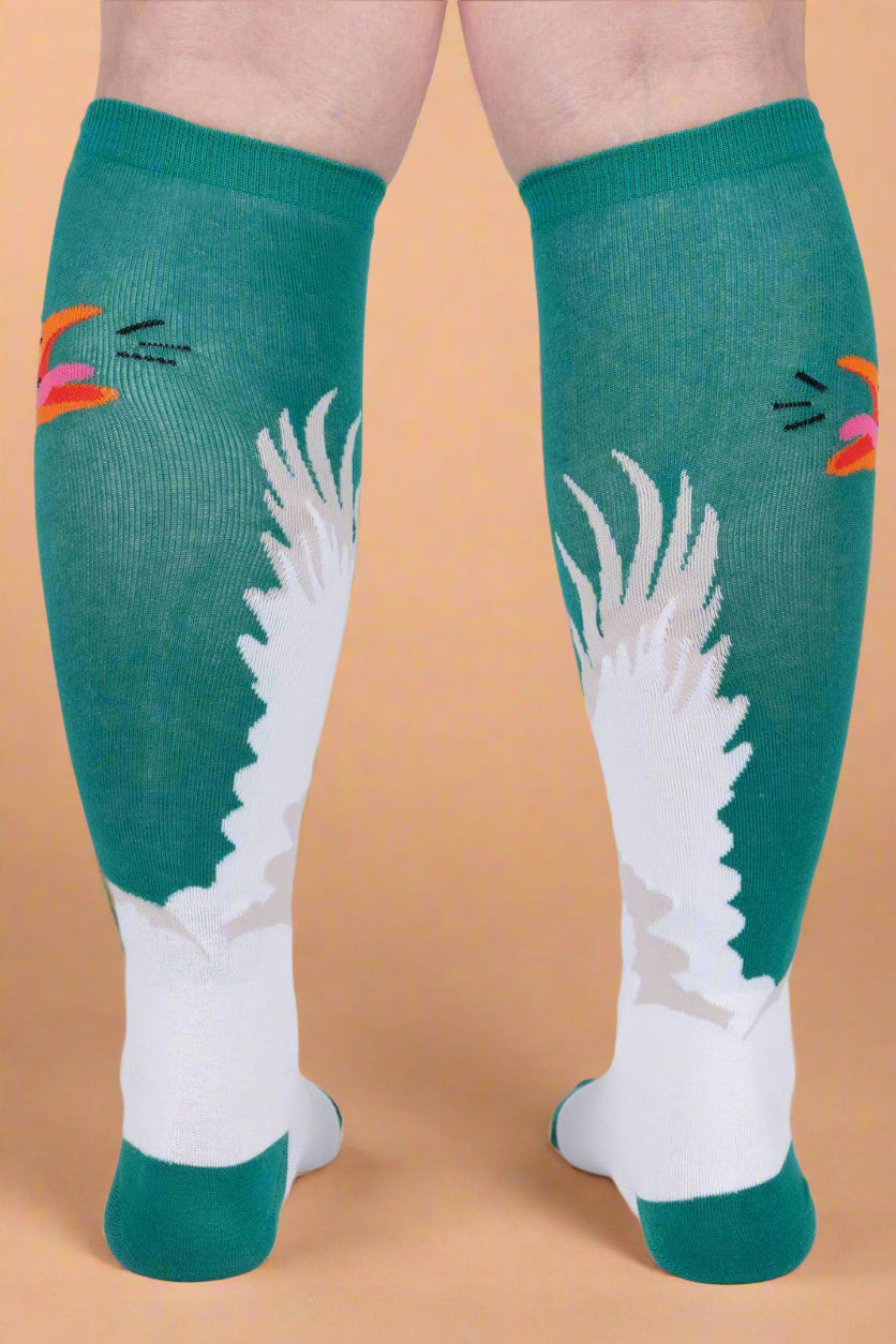 Teal knee-high socks with white wings and colorful accents on a plain background