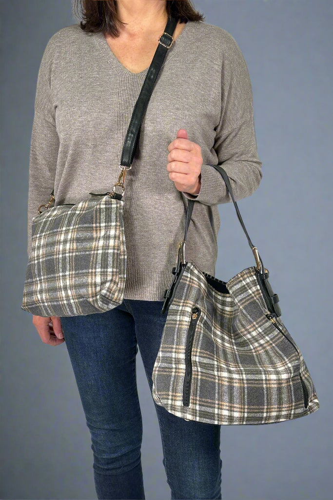 Model is showing off a plaid hobo bag that comes with a small bag inside that can be worn as a crossbody.