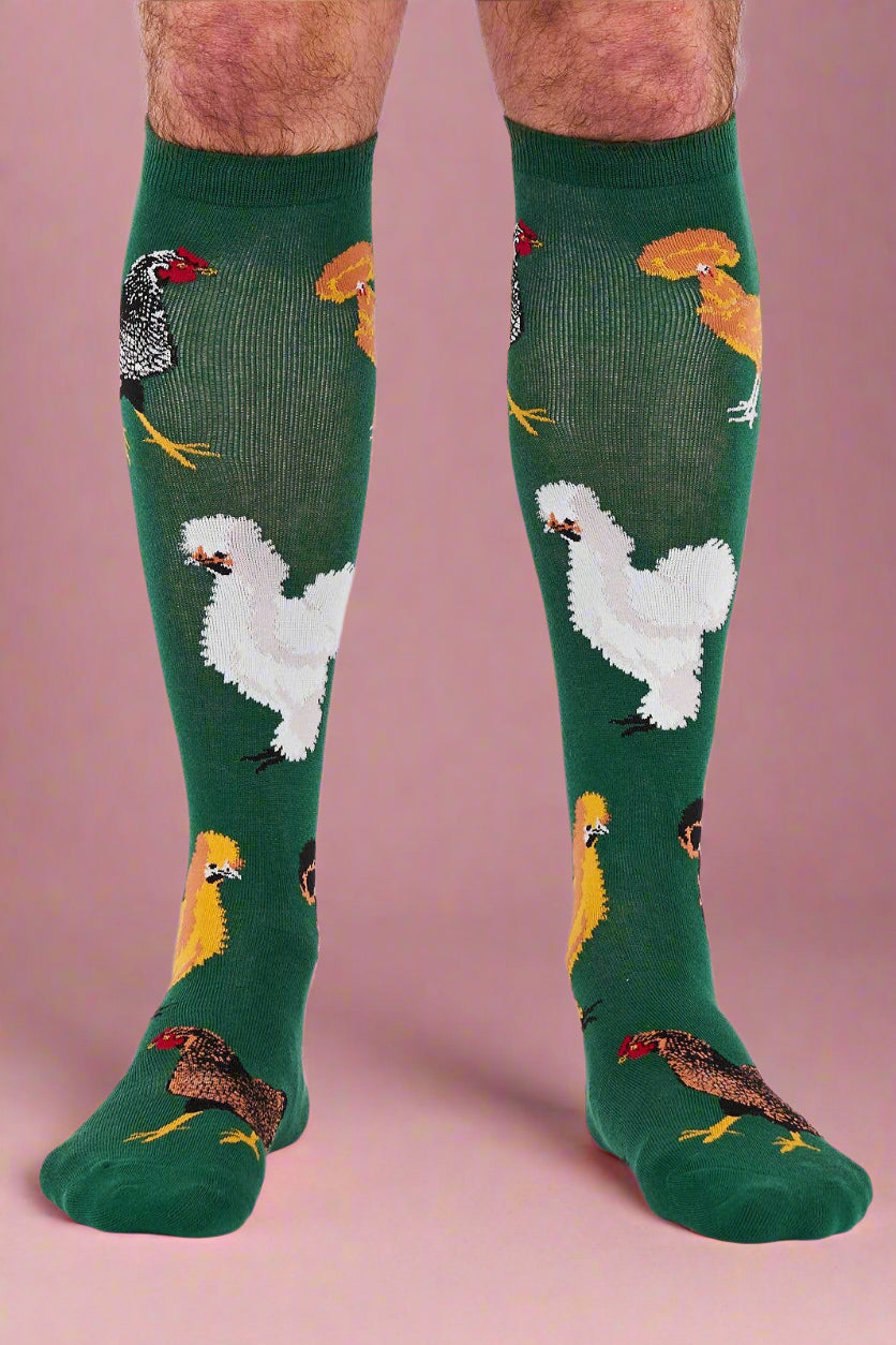 Green knee-high socks with chicken pattern worn by a person on a white background