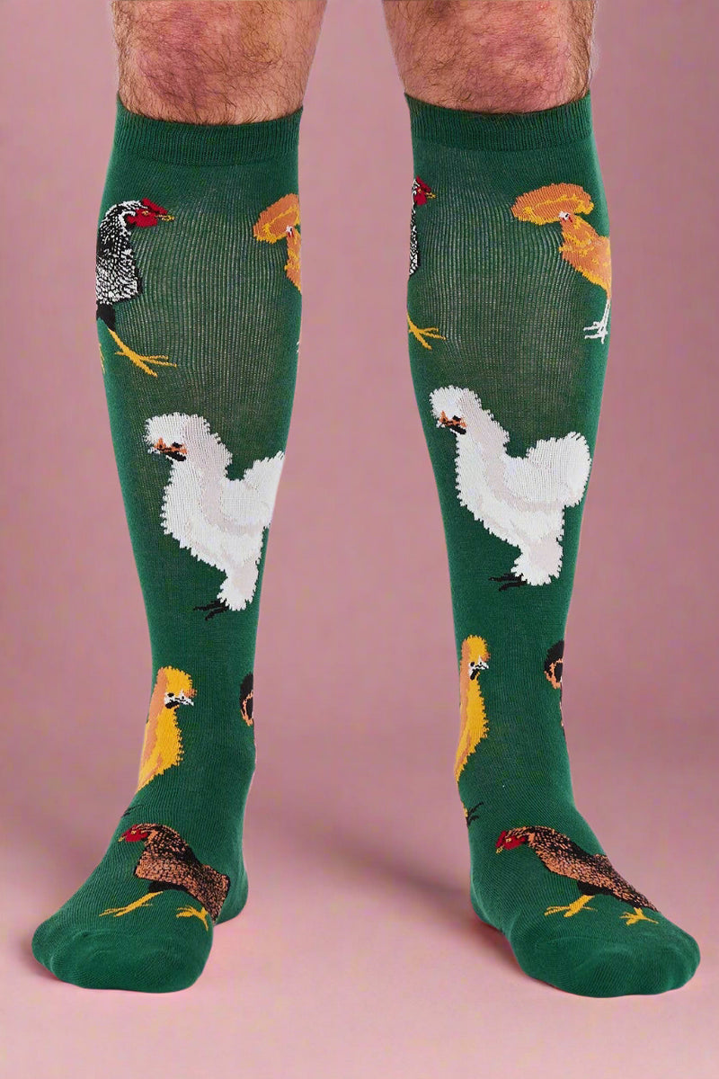 Green knee-high socks with chicken pattern worn by a person on a white background