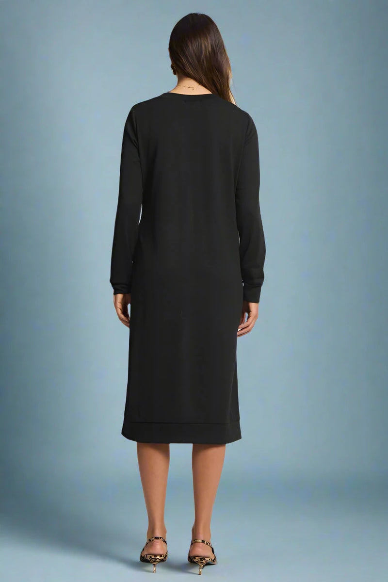 Black dress worn by a person on a plain background