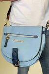 Model is carrying a blue color block cross body bag. 