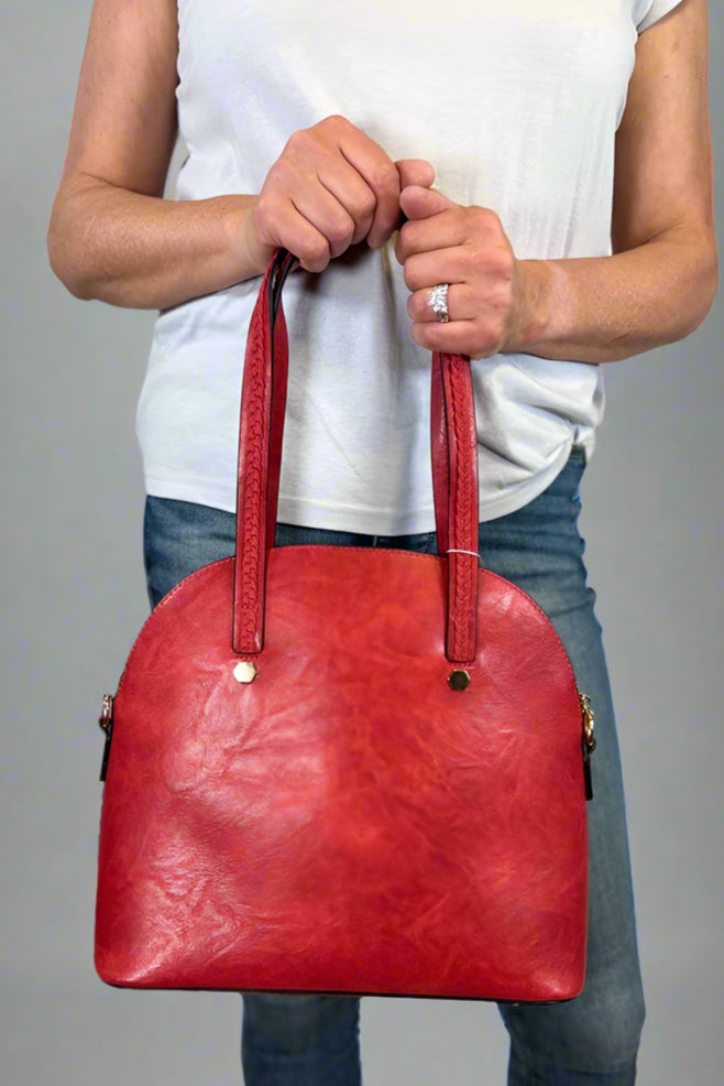 Model is carrying a large red bowler bag. 