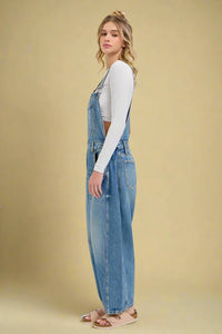 Woman wearing denim overalls on a white background