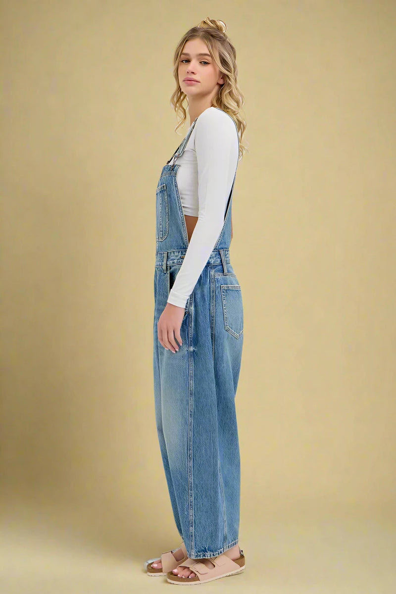 Woman wearing denim overalls on a white background