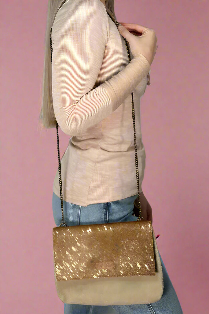 Suede crossbody with long chain strap for wearing as a crossbody or shoulder bag. Gold foil detail on the flap. 