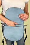 Model is carrying a blue color block cross body bag. 