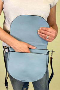 Model is carrying a blue color block cross body bag. 