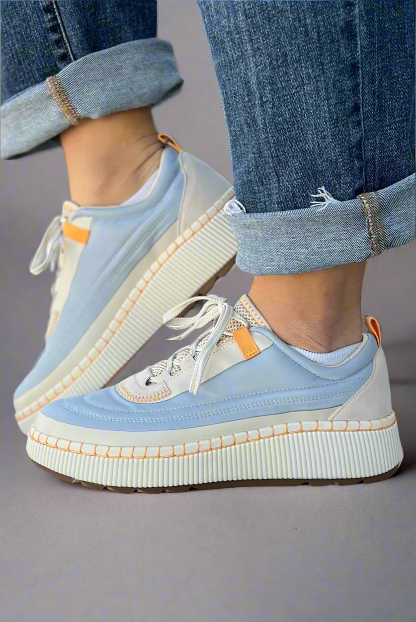 Waterproof blue and white platform sneakers featuring a unique stitching detail on the sole and orange accents. 