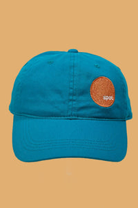 Teal colored cotton baseball cap featuring an embroidered Spot logo.