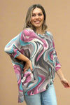 A dolman top in a blue, purple, and grey swirl pattern. It is lightweight and long in length.