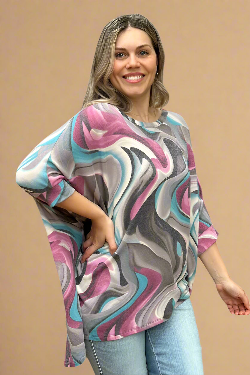 A dolman top in a blue, purple, and grey swirl pattern. It is lightweight and long in length.