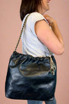 Large quilted black shoulder bag with chain strap. 