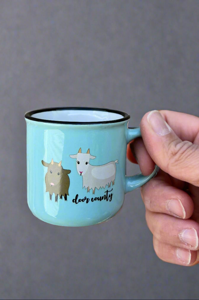 A mini coffee mug in light blue with two goats and ‘door county’ written below them.