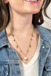Model is wearing a gold necklace with varied celestial charms. 