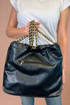 Large quilted black shoulder bag with chain strap. 