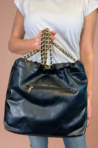 Large quilted black shoulder bag with chain strap. 