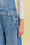 Close-up of blue denim overalls with a white background