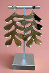 These gold acrylic earrings features Matisse’s abstract leaves.