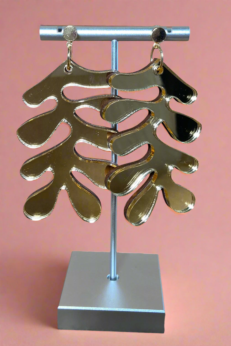 These gold acrylic earrings features Matisse’s abstract leaves.