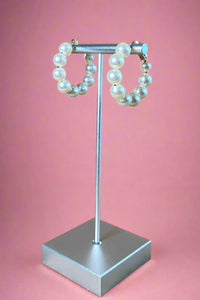 Small sized pearl hoop earrings with gold hardware. 
