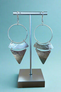 Brushed silver hammered, tiered style earrings on a stand.
