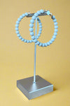 Beaded hoops in a matte grey colored finish.