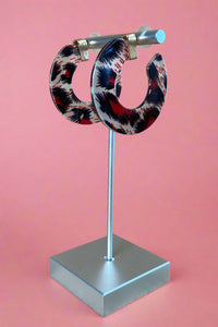 Black, red, and grey colored leopard print acrylic hoop earrings.
