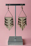 Triangle shape gold dangly earrings that feature small intricate bead dangles.