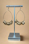 These gold earrings feature a teardrop shape and fringe beads.
