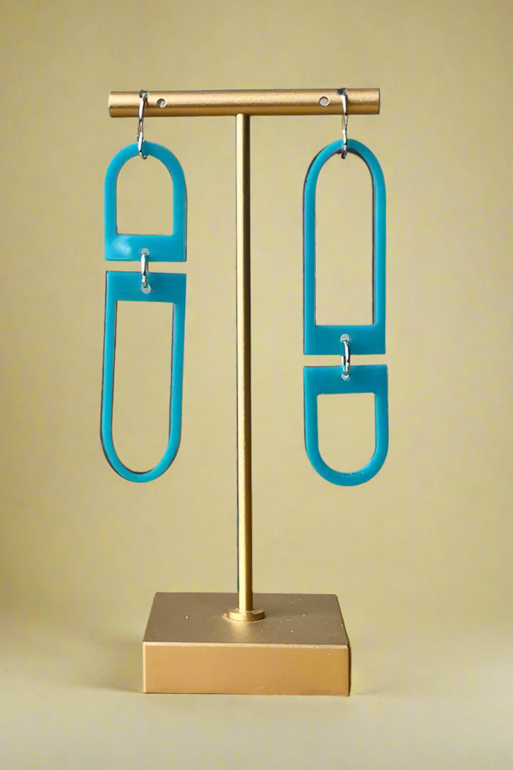 Blue acrylic mismatched geometric shaped dangly earrings with silver hardware. 