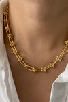 Model wears a gorgeous, adjustable, gold necklace with a knotted chain design.