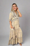 Model is wearing a boho style tiered maxi dress with 3/4 sleeves and pockets. 