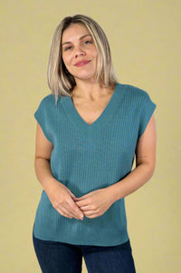 Model is wearing a soft ribbed v-neck sweater vest in a deep teal color.