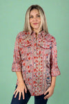 Model is wearing a lightweight pink floral western inspired top with snap buttons.