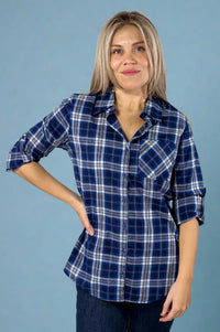 Model is wearing a blue tone plaid button up shirt with a front pocket and sleeves that can be buttoned to 3/4. 