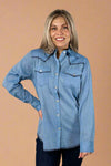 Model is wearing a western style chambray shirt with dark navy contrasting stitching and pearl white buttons.