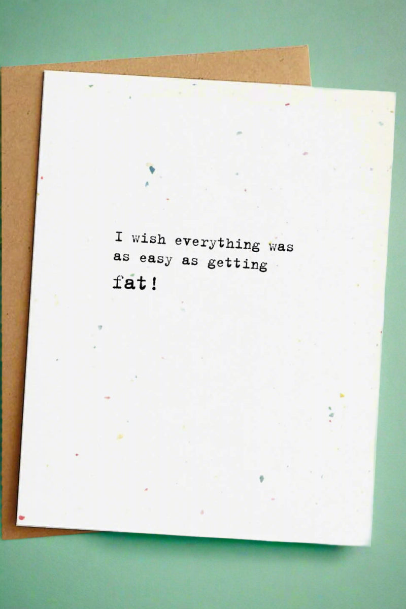 A minimalist greeting card with small black text that reads ‘I wish everything was as easy as getting fat!’