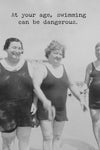 A greeting card with an old black and white phot of three women in full shorts one piece bathing suits and text that reads ‘At your age, swimming can be dangerous.’