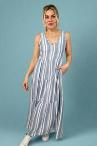 Model is wearing a maxi style linen blend striped dress with tank straps and a v-neck.