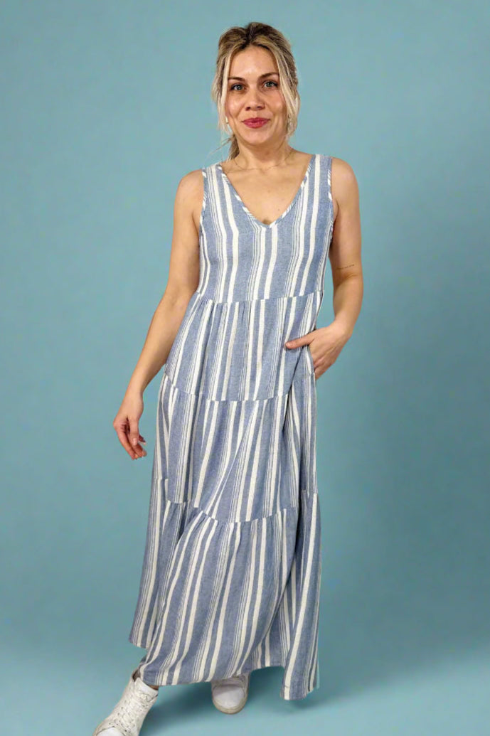 Model is wearing a maxi style linen blend striped dress with tank straps and a v-neck.