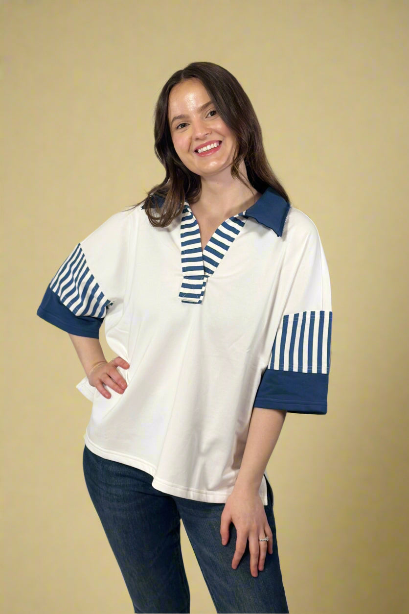 Model is wearing a rugby style short sleeve collared tunic top in crisp white and navy blue.